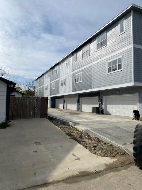 exterior space with central AC unit and a garage