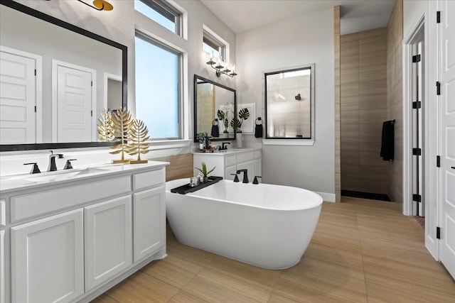 bathroom with a bathtub, vanity, and tile patterned flooring