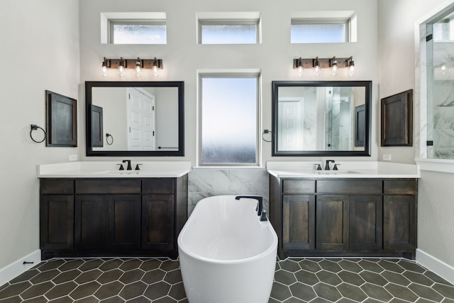 bathroom featuring a bath, vanity, and a healthy amount of sunlight