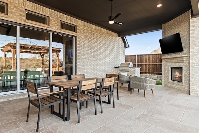 view of patio / terrace with an outdoor brick fireplace and ceiling fan