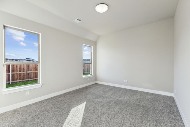 carpeted empty room featuring vaulted ceiling