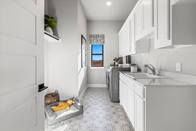 washroom featuring sink, cabinets, and independent washer and dryer