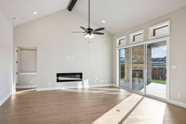 unfurnished living room featuring high vaulted ceiling, hardwood / wood-style floors, and beamed ceiling