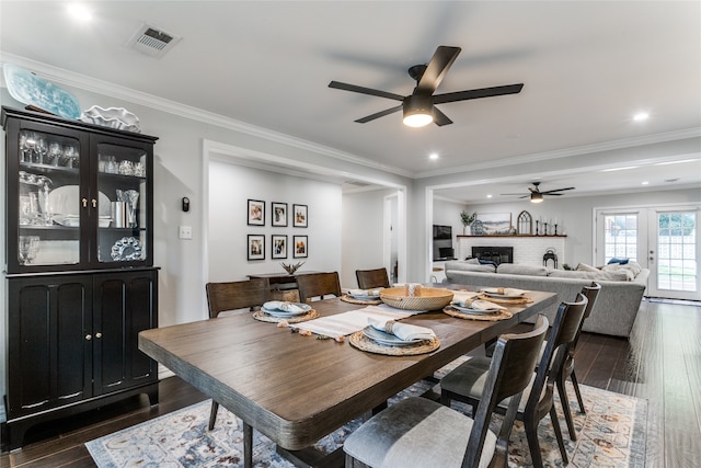 dining area with crown molding, a fireplace, dark hardwood / wood-style floors, and ceiling fan