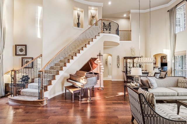 entrance foyer with a notable chandelier, dark hardwood / wood-style flooring, a high ceiling, and ornamental molding