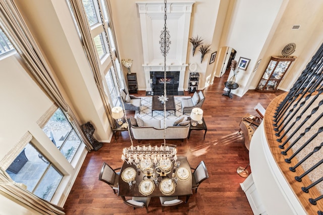 living room featuring dark hardwood / wood-style floors, a towering ceiling, and a wealth of natural light