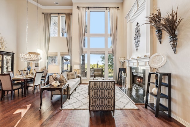 living area featuring crown molding, a fireplace, a healthy amount of sunlight, and hardwood / wood-style flooring