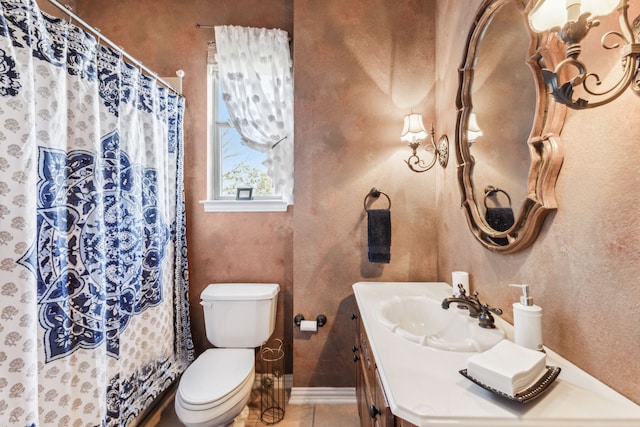 bathroom with tile patterned flooring, vanity, and toilet