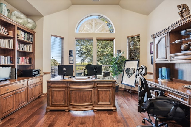 home office with vaulted ceiling and dark hardwood / wood-style floors