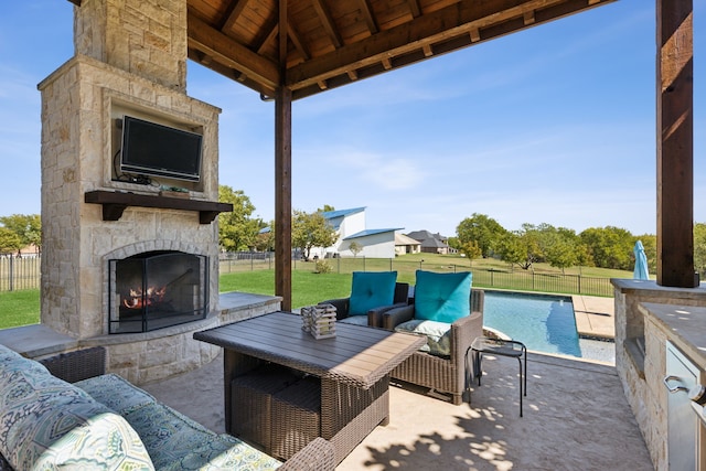 view of patio / terrace with an outdoor stone fireplace, a fenced in pool, and a gazebo