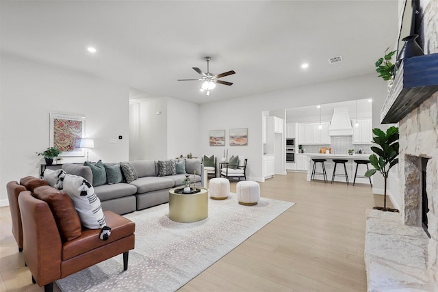 living room with ceiling fan and light hardwood / wood-style flooring