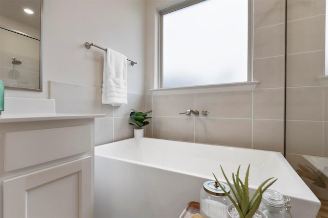 bathroom with tile walls and a bathing tub