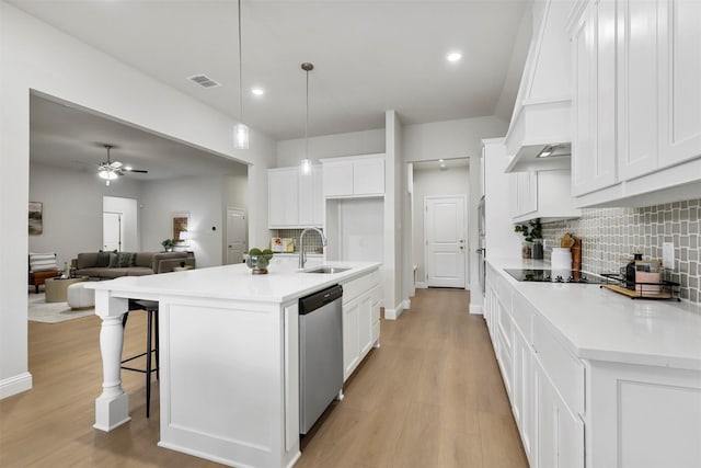 kitchen featuring sink, stainless steel dishwasher, decorative light fixtures, a center island with sink, and white cabinets