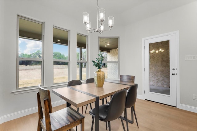 dining room featuring light wood-type flooring and a notable chandelier