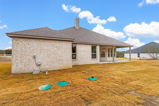 rear view of house featuring a patio area and a yard