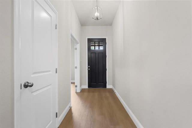 entryway featuring wood-type flooring and a chandelier