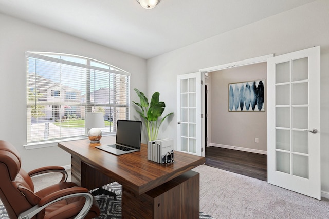 carpeted office space with french doors and baseboards