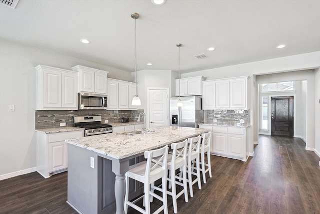 kitchen with dark wood-style floors, baseboards, a sink, white cabinets, and appliances with stainless steel finishes