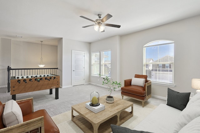 living room with visible vents, a ceiling fan, baseboards, and light carpet