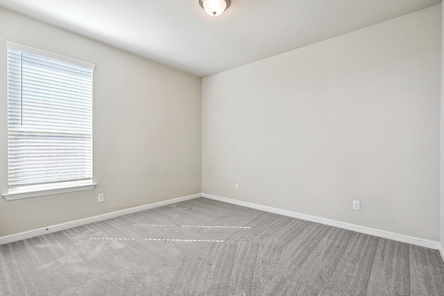 carpeted spare room with baseboards