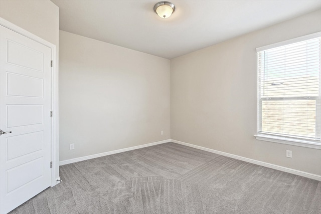 carpeted empty room featuring plenty of natural light and baseboards