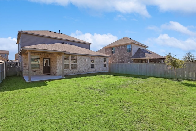 back of property with a patio area, a yard, a fenced backyard, and brick siding