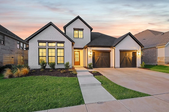 modern inspired farmhouse featuring a garage and a yard