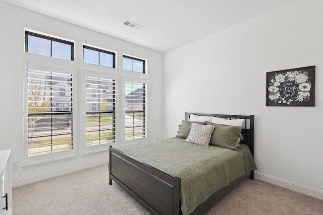 bedroom with light carpet and multiple windows