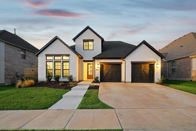 modern inspired farmhouse with a garage and a yard