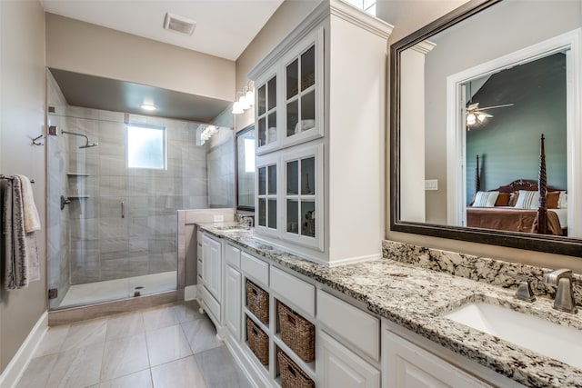 bathroom with ceiling fan, tile patterned flooring, vanity, and walk in shower