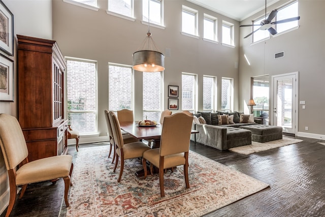 dining room with a wealth of natural light, ceiling fan, crown molding, and a towering ceiling