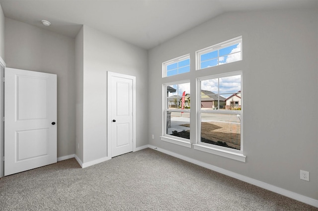 unfurnished bedroom with carpet floors, vaulted ceiling, and a closet