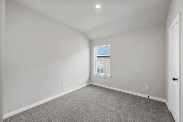 empty room featuring carpet floors and vaulted ceiling