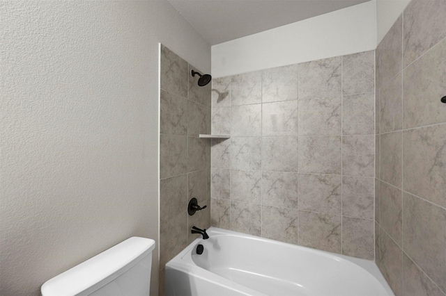 bathroom with tiled shower / bath combo and toilet