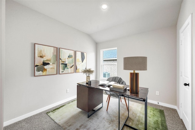 carpeted home office with vaulted ceiling