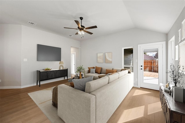 living room with light hardwood / wood-style floors, ceiling fan, and vaulted ceiling