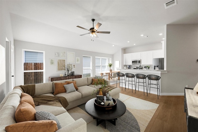 living room with lofted ceiling, ceiling fan, and dark hardwood / wood-style flooring