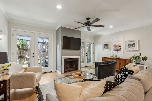 living room featuring ornamental molding, ceiling fan, french doors, and light hardwood / wood-style flooring