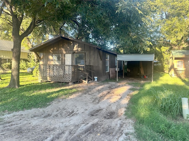 view of outdoor structure featuring a lawn and a carport