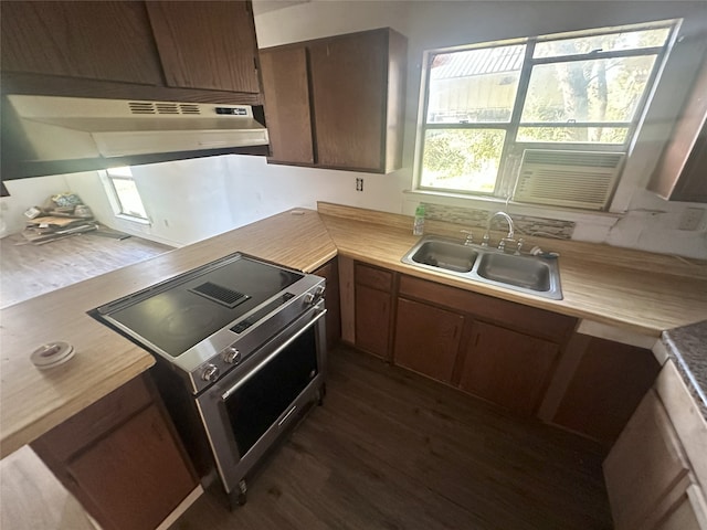 kitchen featuring backsplash, stainless steel stove, dark wood-type flooring, and sink