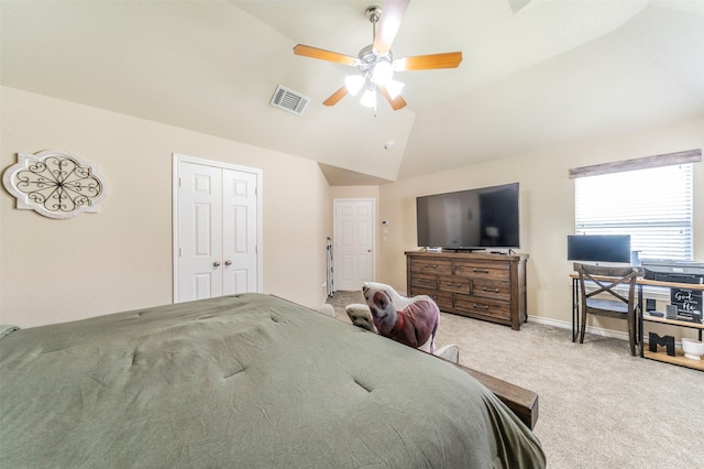 bedroom with ceiling fan, a closet, light carpet, and vaulted ceiling