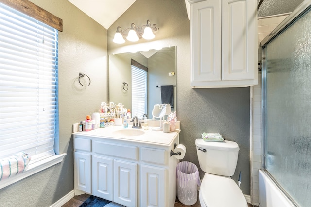 full bathroom featuring vaulted ceiling, vanity, toilet, and shower / bath combination with glass door