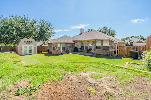 rear view of property featuring a storage shed and a yard