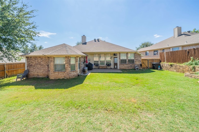 rear view of house with a lawn and a patio