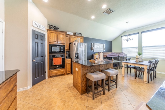 kitchen with a kitchen island, black appliances, lofted ceiling, decorative light fixtures, and a chandelier