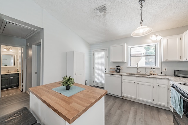 kitchen featuring light wood-type flooring, sink, white cabinets, hanging light fixtures, and white dishwasher