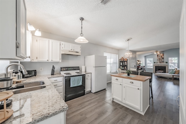 kitchen featuring white cabinetry, white refrigerator, a fireplace, and range with electric cooktop