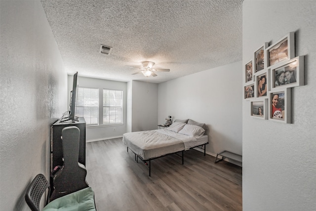 bedroom with ceiling fan, a textured ceiling, and wood-type flooring