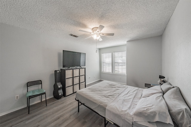 bedroom with ceiling fan, a textured ceiling, and light wood-type flooring