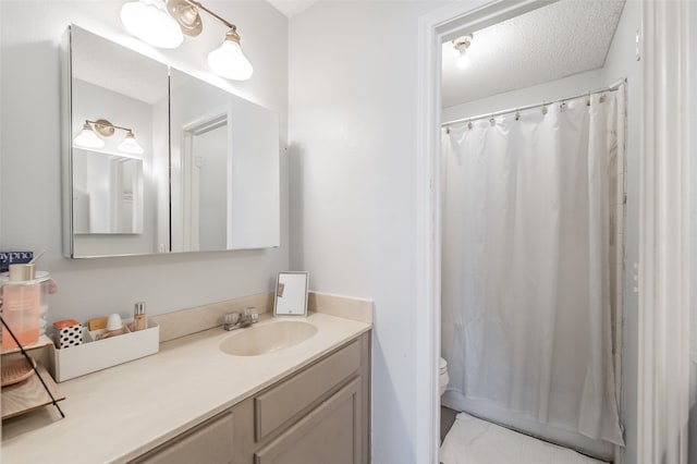 bathroom featuring a textured ceiling, vanity, toilet, and a shower with curtain